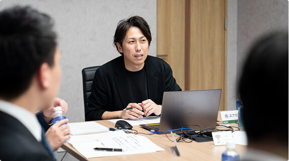 説明会にて話をしている司会者